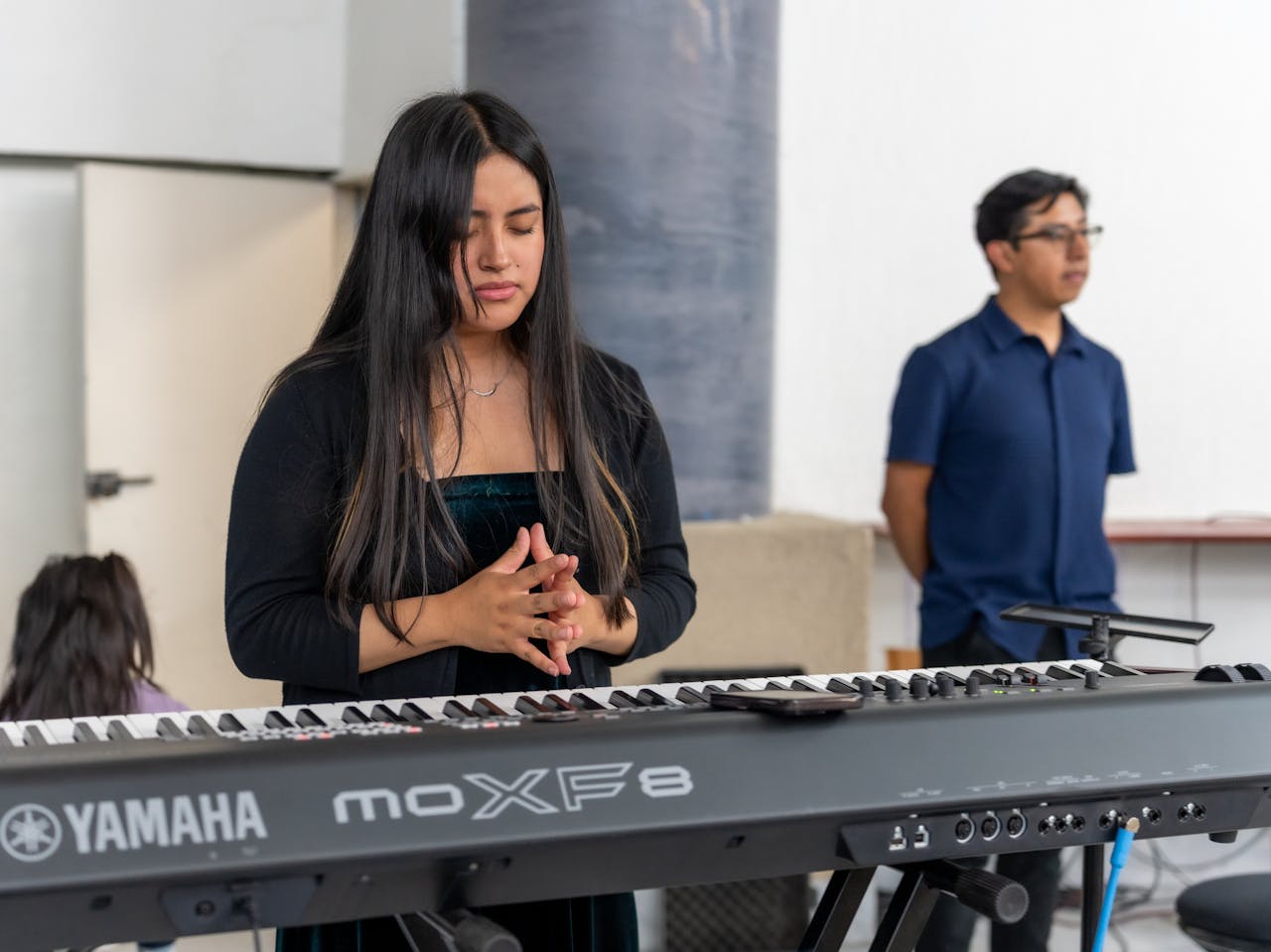 Crafting Captivating Headlines: Your awesome post title goes here A young woman leads worship, playing keyboard with focus and spirituality in CDMX, Mexico.